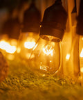20 Pack S14 Replacement Light Bulbs For Outdoor Patio String Lights 11W 120V Warm 2200K Edison Bulbs glowing on grass