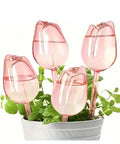 Pink Tulip Watering Globes For Indoor And Outdoor Plants Self Watering Bulbs That Slowly Release Water To Keep Pots Hydrated For 7 To 14 Days No Fuss Easy Care For Busy Plant Parents In A 2 Or 4 Pack, four pink tulip bulbs in a planter