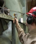 Worker using a Rock Solid LED Stroboscope for motion analysis on industrial machinery showing 30 to 300000 FPM flash rate.