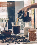 Keep Coffee Beans Fresh As Heck With This Solid 3 Piece Airtight Glass Canister Set Designed For Loose Tea And Spices Compact Footprint Saves Counter Space And Locks In Flavor Straight Up. Hand pouring coffee from a glass French press into a cup with coffee beans in the foreground.