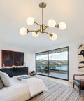 Six Light Sputnik Modern Pendant Chandelier With Opal White Glass Globes Height Adjustable in gold finish in bedroom setting