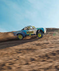 Grom 4x4 Desert RC Truck Ready To Run With Battery And Charger Included climbing sandy hill, blue and white Mojave style