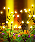 Solar Garden Lights Firefly And Starburst Swaying Lights glowing in garden with orange and purple flowers, bright yellow LED bulbs