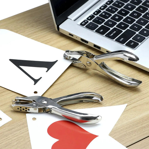 24 Pack One Quarter Inch Single Hole Puncher Set With 5 Sheet Capacity shown on a desk with greeting cards and laptop, metal construction.