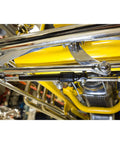 Close-up of chrome steering stabilizer for straight axle hot rods fits hairpin and four bar front suspensions reduces vibration and steering wobble includes seven eighths inch clamp kit for quick install and smoother handling installed under a vehicle.