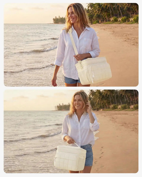 Woman carrying Insulated Puffer Cooler Bag Holds Thirty Two Cans Soft Side Duffel Tote With Double Deck Setup Built For Weekend Warrior Chill Sessions Tailgate Stashes And Day Trip Essentials Beige on beach during sunset.