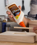Man applying Carpenter's Wood Glue Max 1 Gallon Tan Extra Strength Wood Adhesive That Bonds Stronger Than Wood to wooden dowel