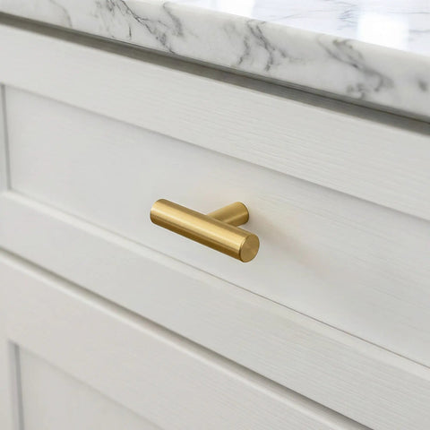 Premium Brushed Brass Cabinet Knobs 2 Inch Dresser Pulls Hardware Set 12 Pack on a white drawer with a marble countertop.
