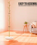 Freestanding Metal Coat Rack With 8 Hooks, Space Saving Hall Tree for Entryway in gold finish in a sunny living room.
