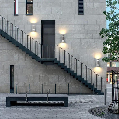 Modern building facade with 2 Pack Outdoor Wall Sconce Lights With Up And Down LED Cylinder Design, 304 Stainless Steel Waterproof Exterior Porch Lighting.
