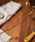 Two Pack Fire Pit Thermocouples Replacement 60x1 Cm 23.6x0.4 In on wooden table with tools and clock