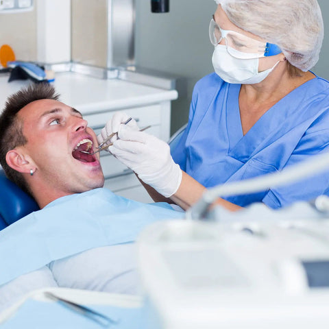Dentist wearing 48 Pack Safety Glasses With Clear Lenses For Work And Lab Eye Protection Goggles examining a patient's mouth
