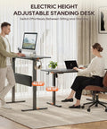 MALOL 56 Inch Electric Standing Desk With Adjustable Footrest Black height adjustable office computer table in home setting.