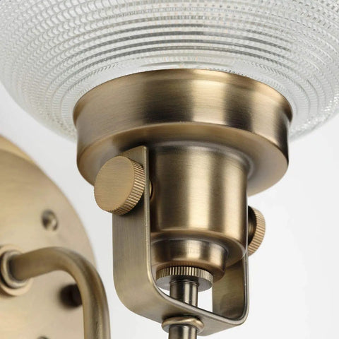 Close-up of vintage brass finish detail on Archie Collection Clear Double Prismatic Glass Coastal Bath Vanity Light Fixture Three Light
