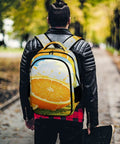 Dope Summer Fruit Print Unisex Backpack With Orange Lemon Lime Pattern held by a person outdoors