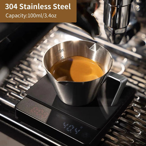 3.4 Oz Espresso Cup With Handle Premium Stainless Steel Cappuccino Accessories Double Spout Measuring Cup With Dual Scale Latte Shot Mug With V Shaped Mouth 100 Ml filled with espresso on scale