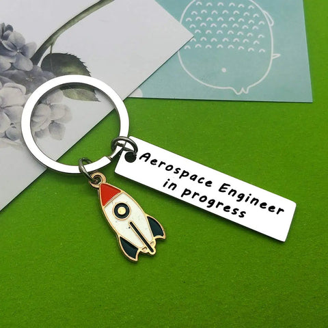 Funny Aerospace Engineer Keychain Gift For Graduation And Appreciation with rocket charm on green background