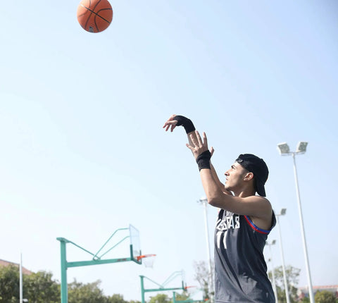 Person playing basketball wearing Two Pack Wrist Compression Straps And Wrist Braces For Fitness And Weightlifting, Black.