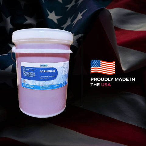 Kick Ass Heavy Duty Low Foam Auto Floor Cleaner Industrial Strength Concentrate in 5-gallon container on American flag backdrop.
