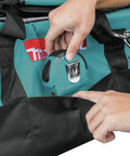 Person placing a tape measure in a pocket of the Heavy Duty 23 Inch Contractor Tool Bag With Double Wall Construction