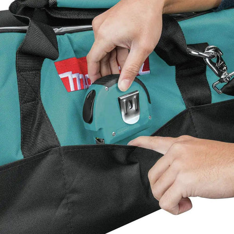 Person placing a tape measure in a pocket of the Heavy Duty 23 Inch Contractor Tool Bag With Double Wall Construction