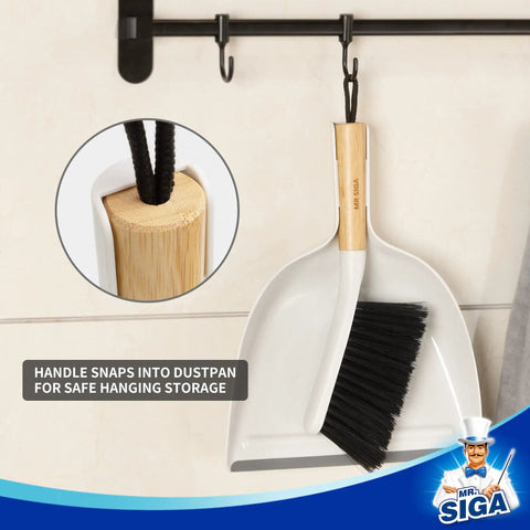 Portable Dustpan and Brush Set With Bamboo Handle in White hanging on a hook; close-up of bamboo handle loop.