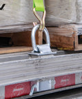 Silver Stake Pocket D Ring Assembly Set for Trailers securing cargo on a steel frame with a tie-down strap attached