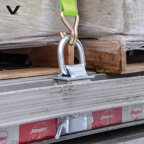 Silver Stake Pocket D Ring Assembly Set for Trailers securing cargo on a steel frame with a tie-down strap attached