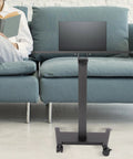 Height Adjustable Standing Desk Podium With No Sweat Foot Pedal And Smooth Roll Casters For Teachers Ergonomic Mobile Lecture Stand with laptop next to person on couch.