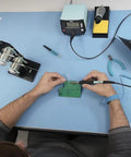 Person using ESD Soldering Mat Blue 600mm By 900mm Pro Grade Large Work Surface With Two 10mm Press Stud Connectors for electronics work.