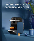 Pixie Espresso Machine By DeLonghi In Dark Blue on counter with espresso cup and capsules