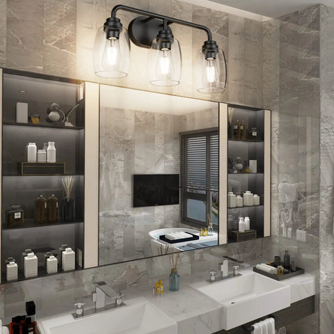 Three Light Black Vanity Light Fixtures Over Mirror With Clear Glass Shades in a modern bathroom