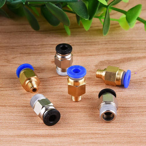 Front view of 6 brass pneumatic push-fit fittings with blue and black seals for PTFE tubing, on wood surface