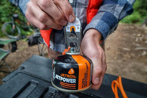 Hand holding Jetpower Fuel Canisters For Camping Stoves Two Pack 100 Gram Iso Butane Propane Mix for Backpacking High Vapor Pressure