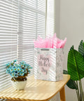 Large 13 Inch Gift Bag With Tissue Paper And Greeting Card For Mother's Day Birthdays Weddings Eco Friendly 3 Sheets Pink Tissue Included Ready To Gift In Style on table next to flowers