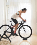 Woman cycling on Magnetic Bike Trainer Stand For Indoor Cycling And Home Gym Use Foldable Stationary Bicycle Roller