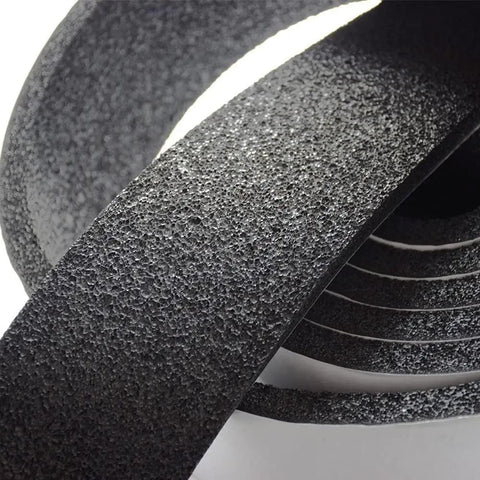 Close-up of Pipe Insulation Foam Wrap Tape Self Adhesive With High Resilience, textured black surface, coiled arrangement
