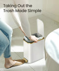 Person using Compact Bathroom Trash Can With Lid And Soft Close, 5 Liter Stainless Steel Slim Waste Basket With Removable Inner Bucket, Step Pedal, White And Gold Trim.