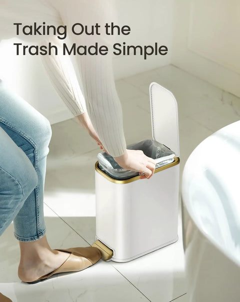 Person using Compact Bathroom Trash Can With Lid And Soft Close, 5 Liter Stainless Steel Slim Waste Basket With Removable Inner Bucket, Step Pedal, White And Gold Trim.