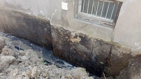 Foundation wall showing moisture damage needing Kickass Rubberized Waterproofing Sealant For Foundations And Flat Low Slope Roofs Concrete Wood Metal Black Five Gallon Multi Purpose Coating Built Damn Tough For Blazing Heat Or Freezing Cold With Knockout Flexibility For Serious Indoor Outdoor Repairs.