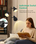 Woman reading under Three Adjustable Rotating Heads Go-To Tree Floor Lamp In Black Industrial Rustic Style with individual switches.