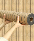 Effortless Peel And Stick 3D Wall Panels Self Adhesive Soundproof Removable PVC Slat Tiles Dark Brown Wood Grain roll displayed by hands.