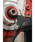 Close-up of indexing twin hook oil and grease seal puller with 14 locking positions removing a seal from metal housing