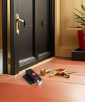 8 Pack Push Latches for Cabinets and Drawers With Spring Lock No Fuss, shown near black door with gold handle on wood floor