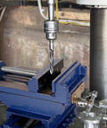 Rock Solid Cross Slide Drill Press Vise Featuring Six Inch Jaw Opening And Smooth Xy Slides For Hassle Free Benchtop Milling Woodworking And Garage Project Builds in use with drill bit.