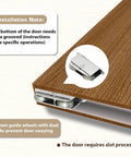 Concealed Sliding Barn Door Hardware Kit With Soft Close For 24 To 28 Inch Passage Openings detail view of guide wheels on wooden panel