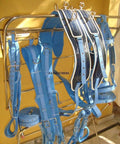 Two Tone Synthetic Patent Leather Driving Harness For Double Horse Cart With Extra Padding hanging on a rack.