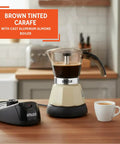Dang Compact Two Cup Electric Espresso Maker With Cool Touch Handle Brews Rich Smooth Coffee straight up on a kitchen counter.