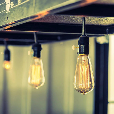 4-pack brass metal lamp switch knobs for standard light sockets on a hanging Edison bulb fixture.