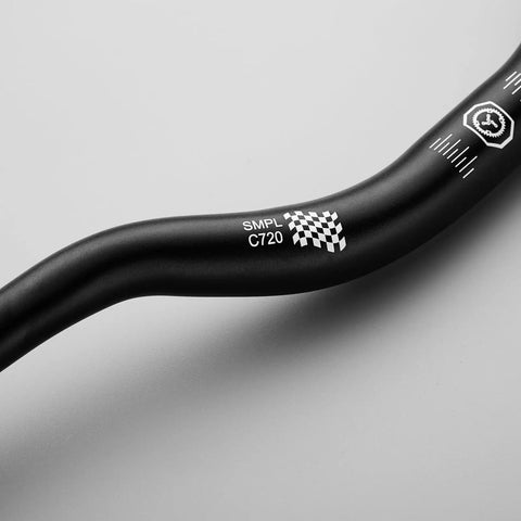 Close-up of Smpl Mountain Bike Handlebar 31.8mm Diameter 50mm Rise 720mm Width Aluminum Alloy Black showing details on bar surface.